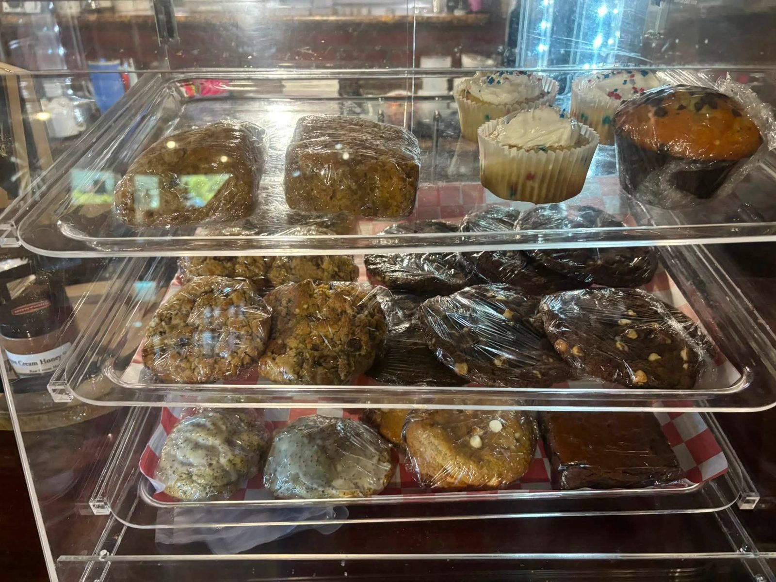 Bakery case of fresh muffins and baked goods