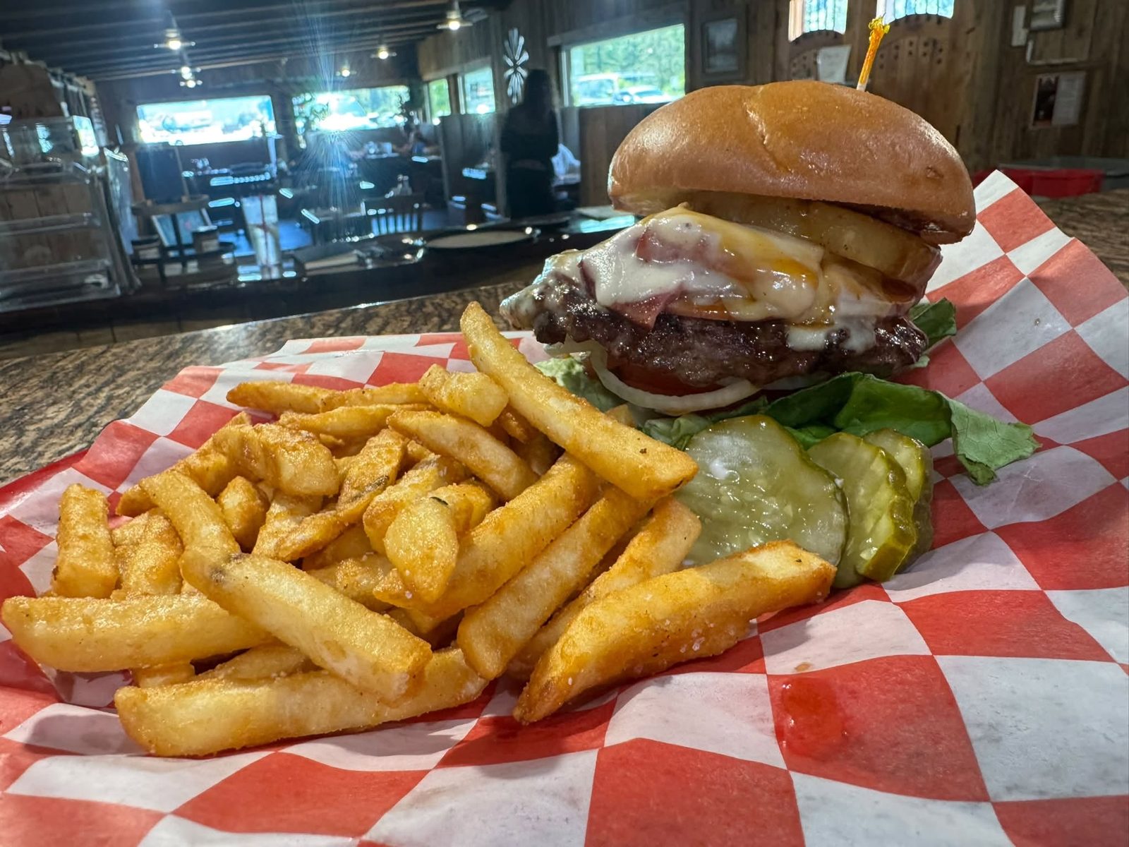 Cheeseburger and crispy fries on a checkered paper liner